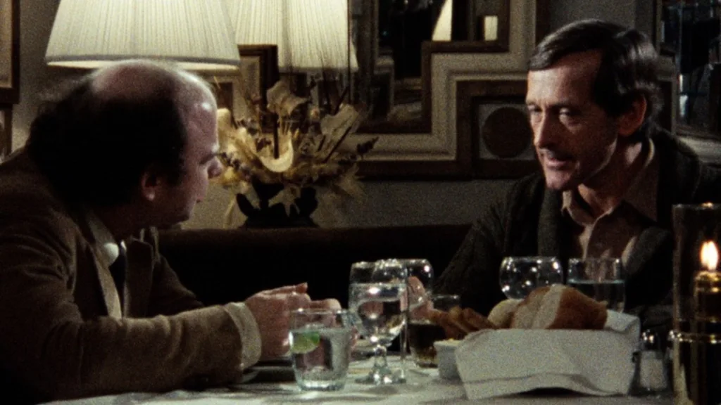 Cena do filme Meu Jantar com André. Os dois personagens principais estão sentados numa mesa de restaurante conversando. O texto usa isso como uma brincadeira imaginando dois amigos conversando sobre o metafórico Jogo Baseado na Cultura Brasileira™