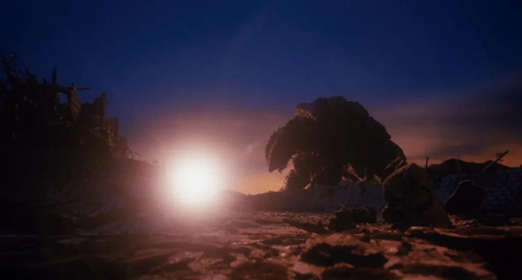 Cena do filme Gamera 2: O Ataque de Legião. Gamera é visto caído de longe ao nascer do sol em meio a uma cidade destruída