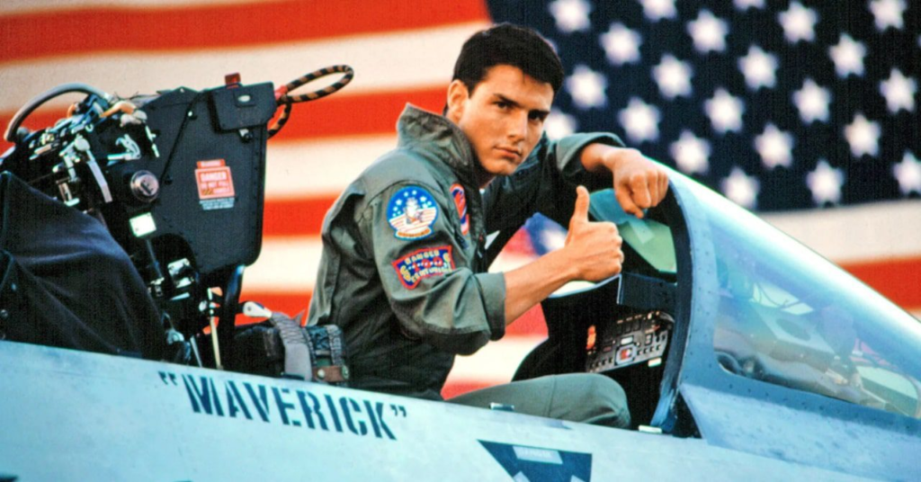 Imagem do clássico dos anos 80, Top Gun, mostrando o Maverick, interpretado por Tom Cruise, num dos caças olhando para a câmera com o polegar erguido