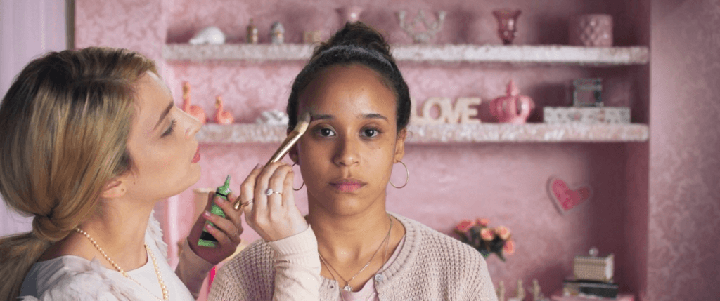 Cena de Medusa, filme brasileiro, mostrando a protagonista Mariana servindo de modelo pra sua amiga influencer evangélica, Michele, num vídeo de maquiagem