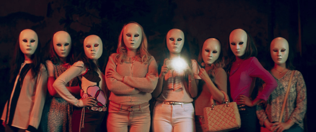 As Preciosas usando suas máscaras e gravando uma das suas vítimas depois de a espancarem por considerá-la uma mulher "impura"