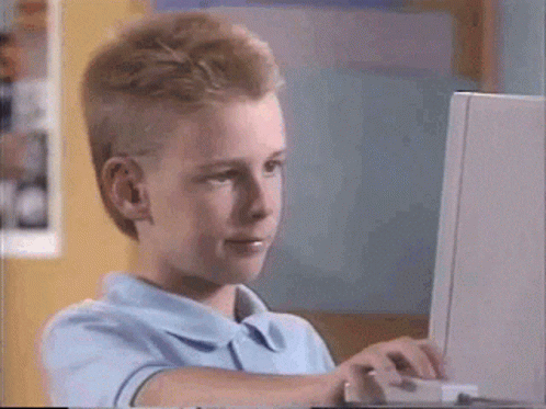 GIF popular de um menino olhando para o computador depois fazendo um sinal de joinha pra câmera enquanto balança a cabeça em aprovação